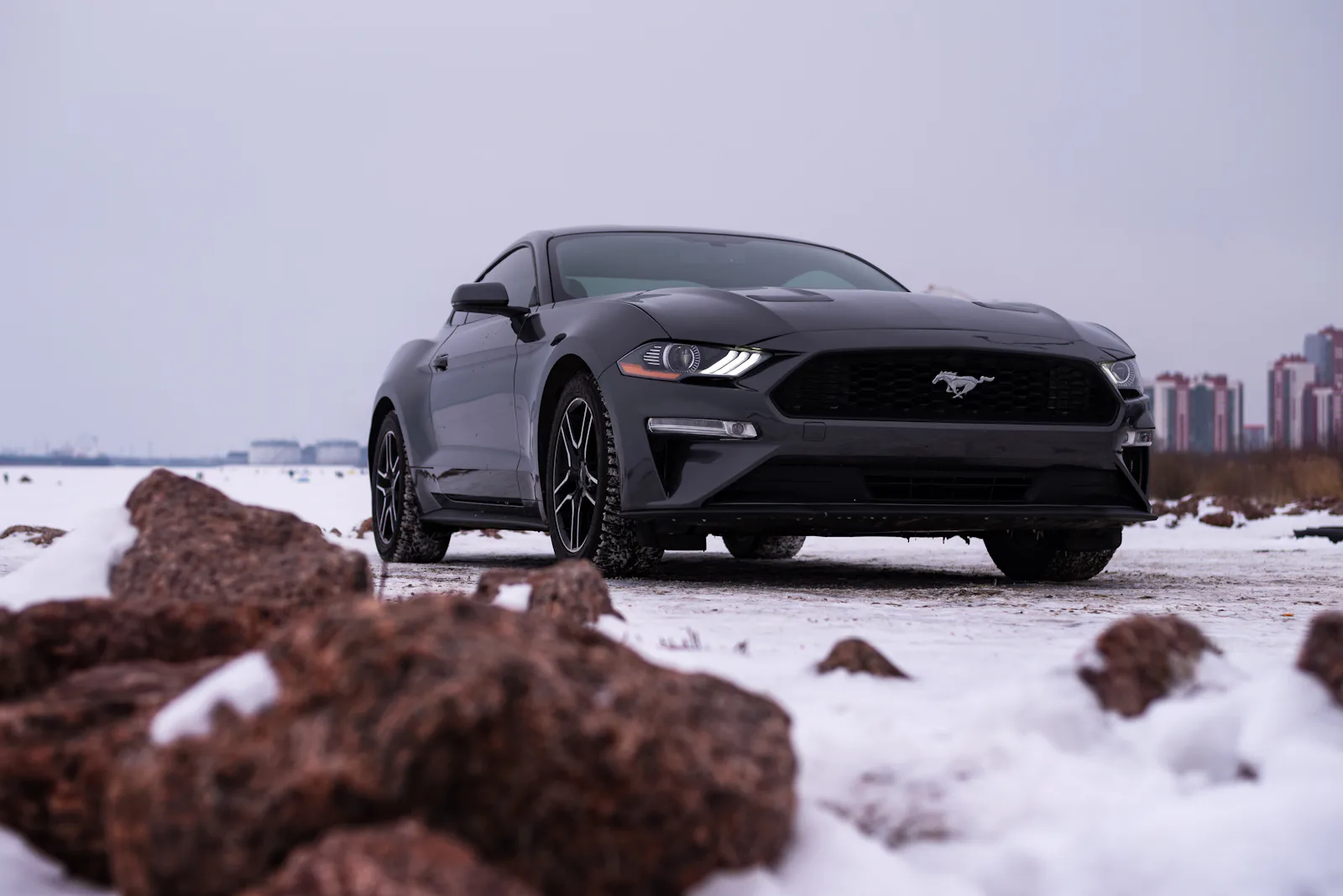 Ford Mustang noire sur route enneigee