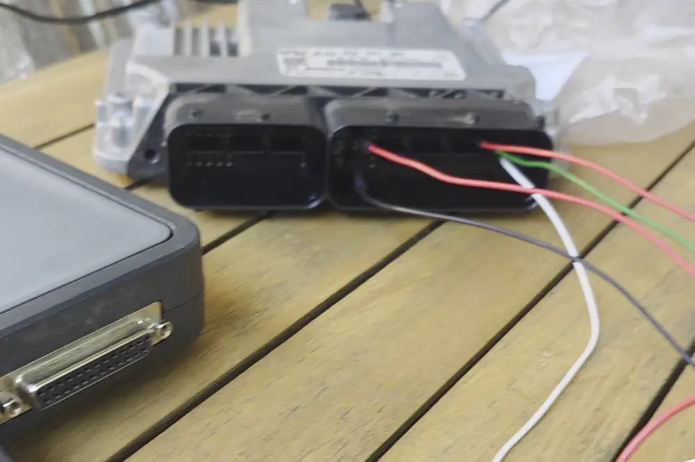 Calculateur moteur câblé sur table pour une lecture en bench avec la valise Alientech KESS V3